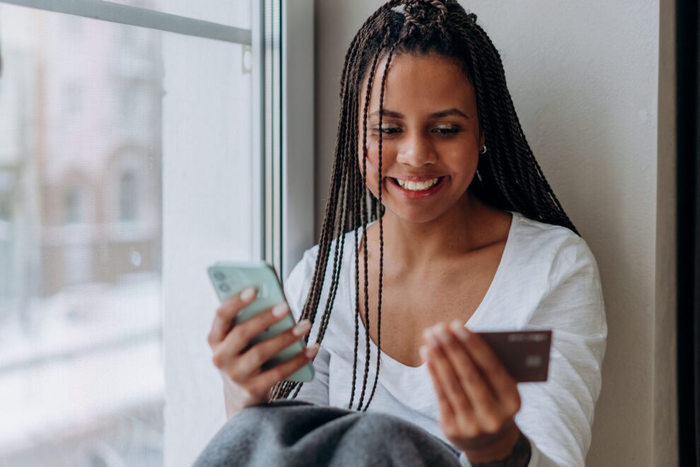 Woman smiling while completing a mobile payment.